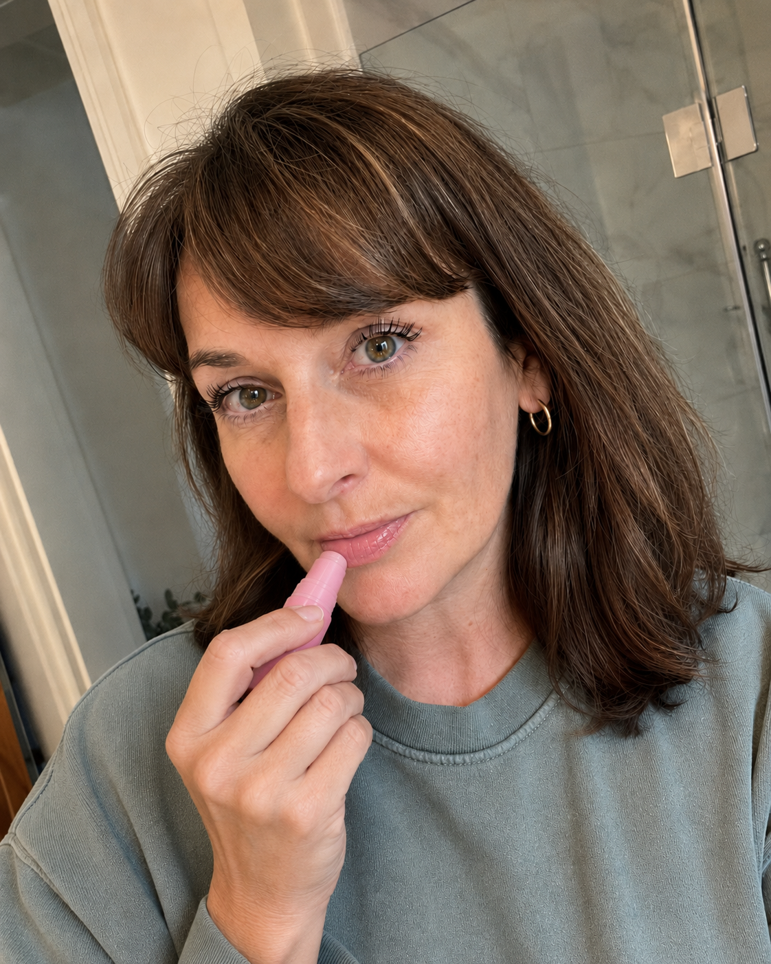 Woman holding REFLATE balm stick